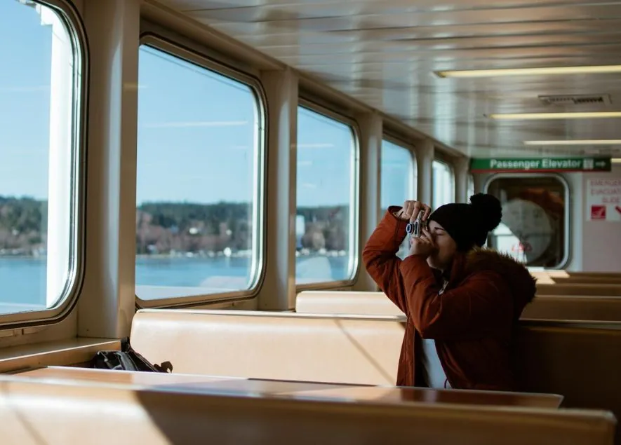 Person sitting taking a picture out a window near the Jay