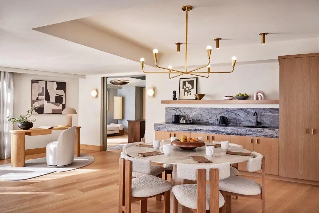 Spacious suite with a dining area, kitchenette, and workspace featuring modern decor at The Jay Hotel.
