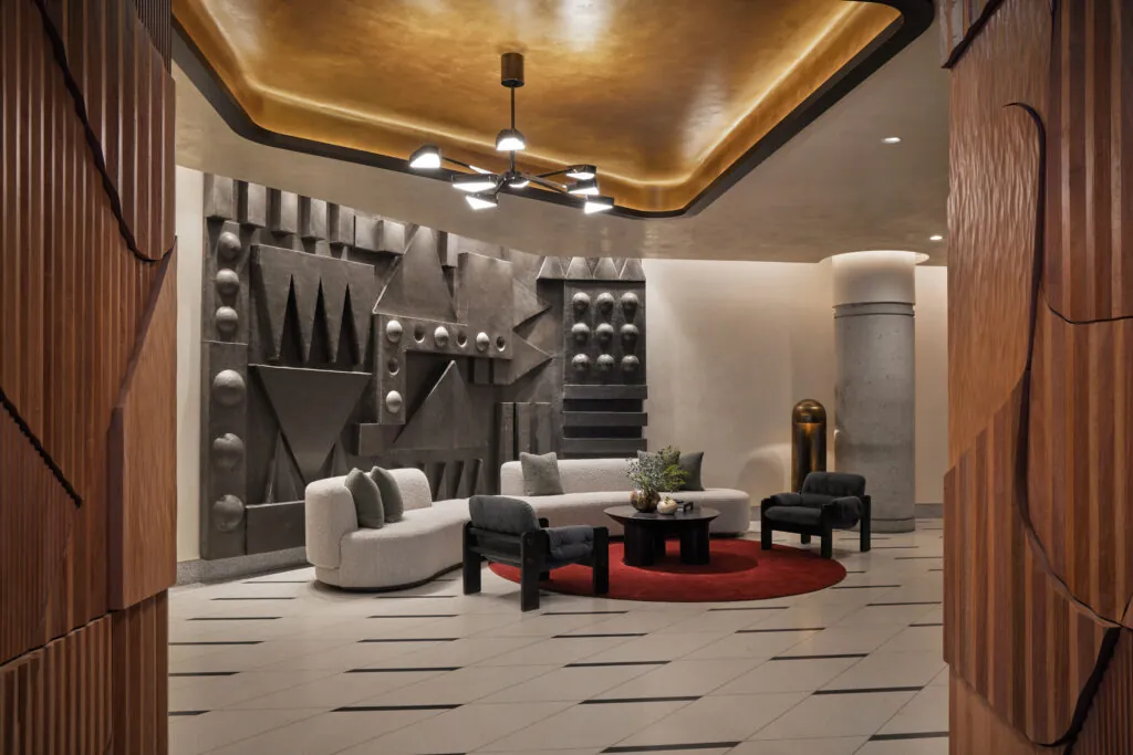 Stylish hotel lobby with modern geometric wall art and cozy seating at The Jay Hotel.